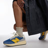New Balance 370 trainers in blue and yellow